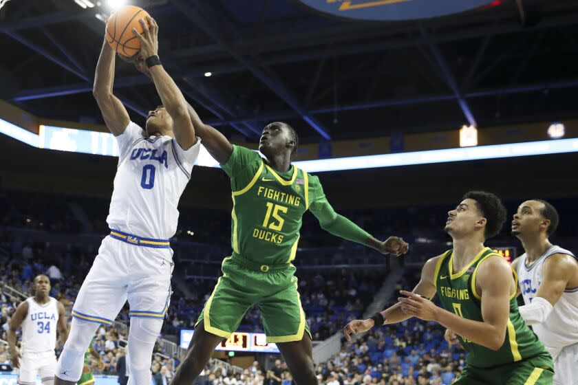 Los Angeles, CA - December 04: UCLA Bruins guard Jaylen Clark, left, and Oregon Ducks forward Lok Wur battle for the rebound during the second half at Pauley Pavilion on Sunday, Dec. 4, 2022 in Los Angeles, CA.(Allen J. Schaben / Los Angeles Times)