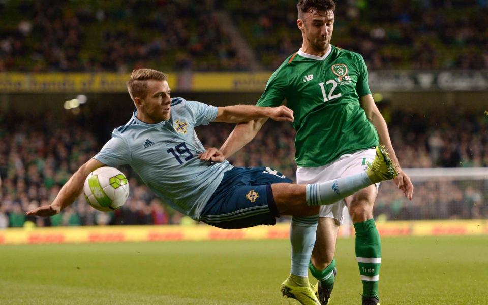 Jamie Ward swings at thin air as Enda Stevens challenges for the ball - Sportsfile