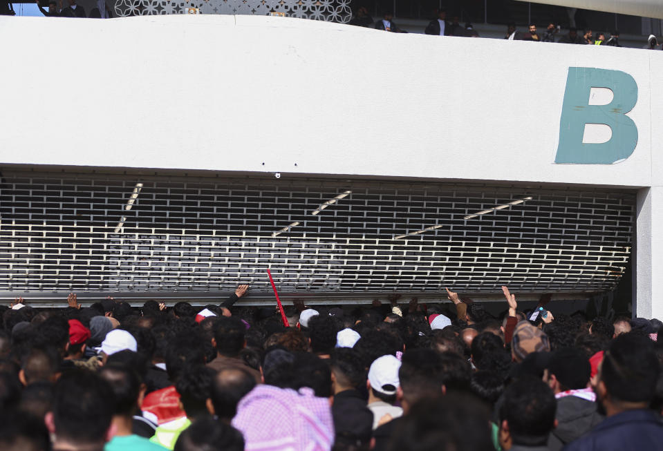 Iraqi soccer fans try to enter the Basra International Stadium in Basra, Iraq, Thursday, Jan 19, 2023. A stampede outside the stadium has killed and injured a number of people. (AP Photo/Anmar Khalil)