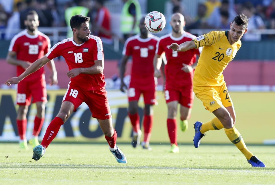 Australia's defender Trent Sainsbury , right, and Palestine's defender Day Dabbagh go for the balld uring the AFC Asian Cup group B soccer match between Australia and Palestine at Al Maktoum Stadium in Dubai, United Arab Emirates, Friday, Jan. 11, 2019. (AP Photo/Hassan Ammar)