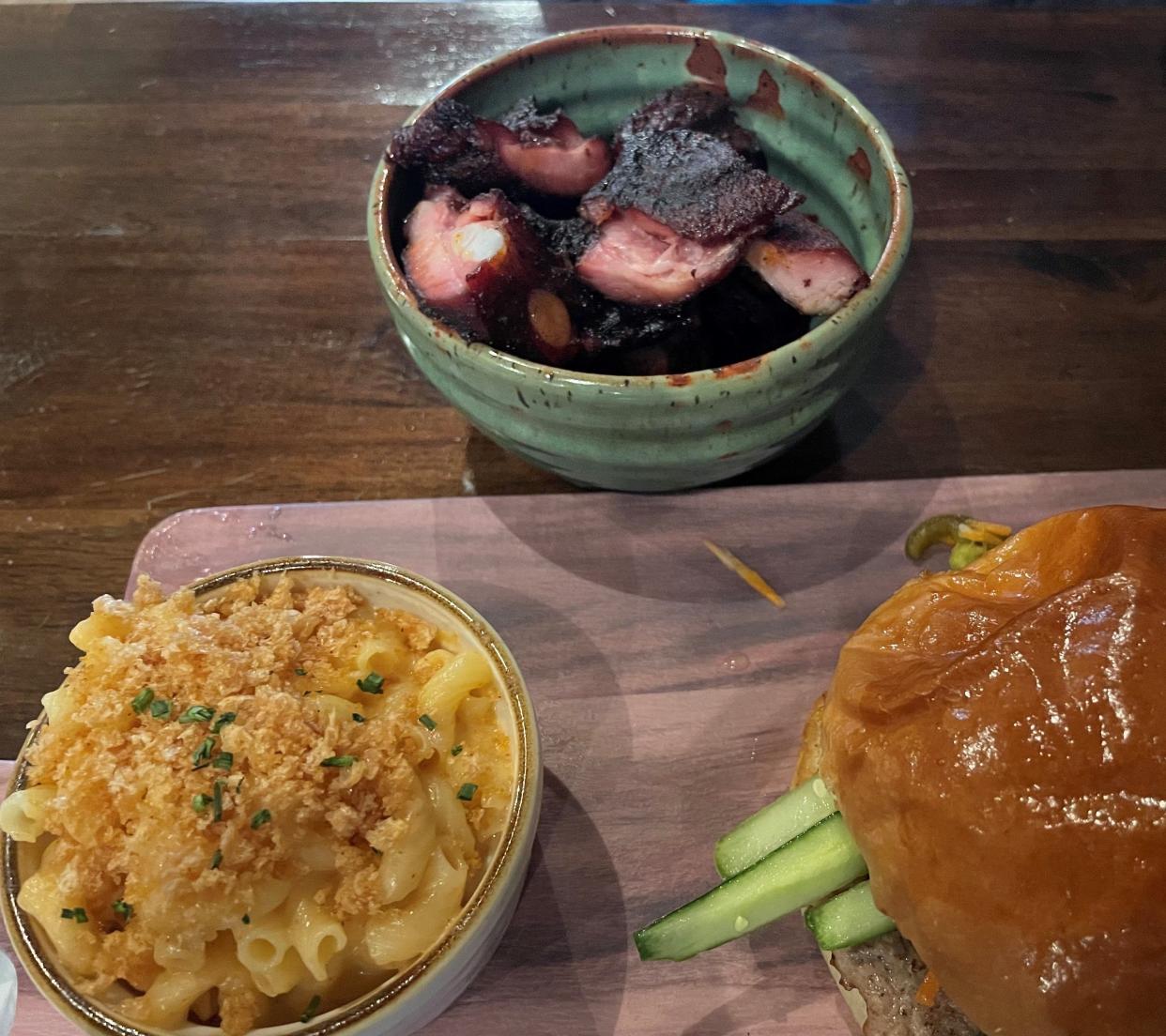 Menu items at the Humble Hog include, from left, chipotle mac and cheese, rib tips — served in a ceramic bowl created by a local artisan — and pork burger banh mi, which is a pork sandwich with a Vietnamese twist.