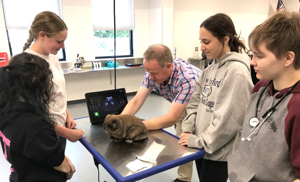 Dr. Jeremy Murdock  describes how an ultrasound examination is conducted on a  rabbit while  freshmen  Charlotte Neider, Molly LaBrie, Maddyx Gaudalupe,and  Sophie Bettencourt observe the instructions on May 23.