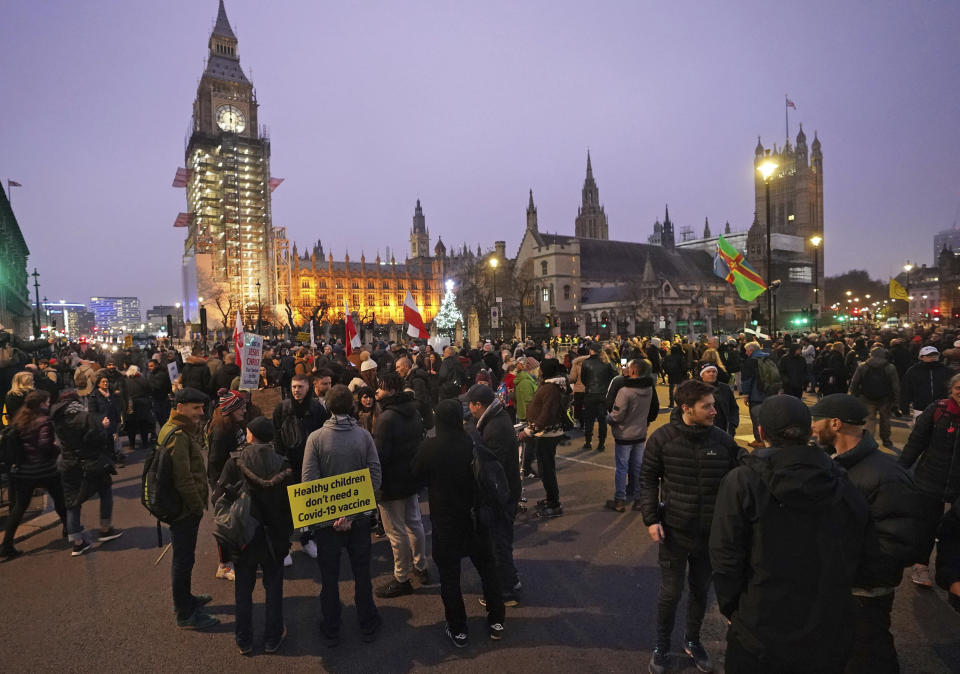 Anti -COVID-19 vaccination protesters demonstrate on Parliament Square in London, Saturday, Dec. 18, 2021. Hundreds of people protested in London Saturday, blocking traffic as they marched with signs bearing slogans such as “Vaccine passports kill our freedoms” and “Don’t comply.” (Ian West/PA via AP)