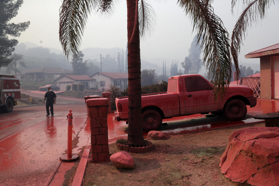 <p>A truck and a street are covered in fire retardant dropped by an air tanker as crews battle a wildfire Friday, Aug. 10, 2018, in Lake Elsinore, Calif. (Photo: Marcio Jose Sanchez/AP) </p>