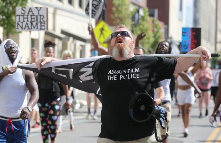 L'activiste de TikTok Russel Tee (@jolly_ginger) marche avec des manifestants sur Main Street le dimanche 3 juillet 2022 à Akron.