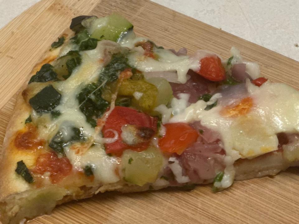 slice of veggie pizza on cutting board