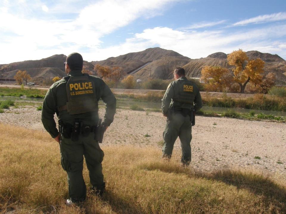 United States Border Patrol agents Carlos A. Rivera, left, and Joel Freeland, observe the borderland near Sunland Park, New Mexico, on Dec. 29, 2021. The two remarked how human smuggling is rivaling illegal drugs as part of the cartel business.