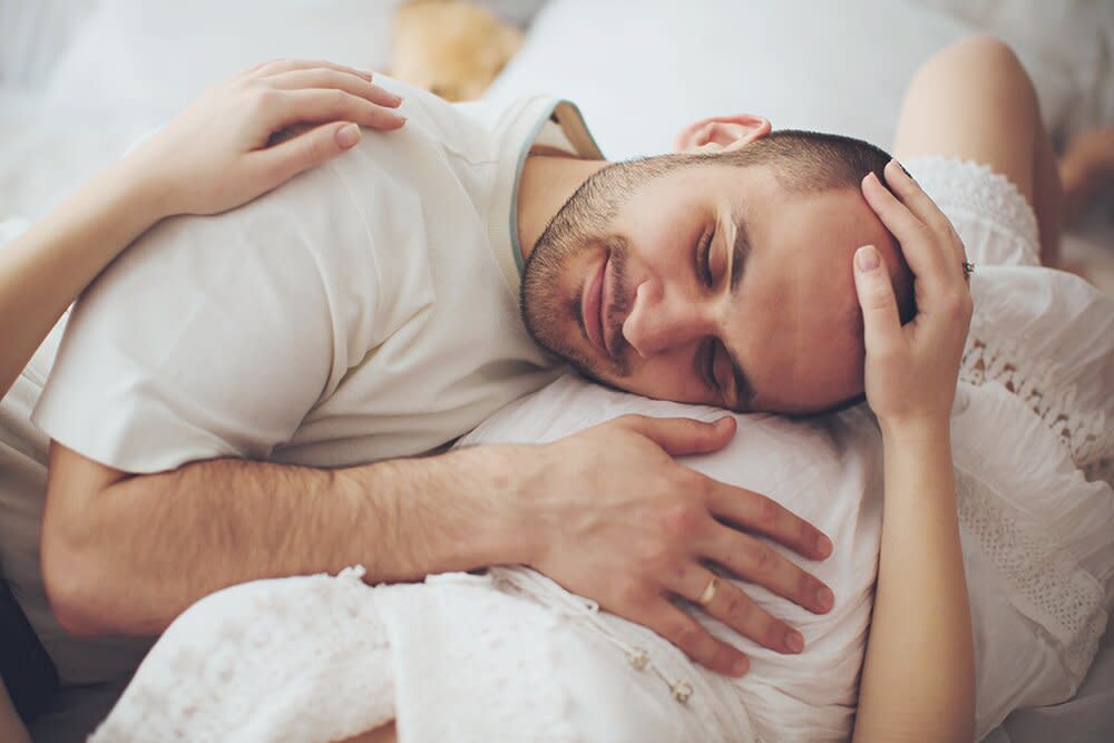 Dad with head and hand on pregnant wife's belly