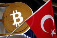 A bitcoin logo is seen next to Turkish flag at a cryptocurrency exchange shop in Istanbul