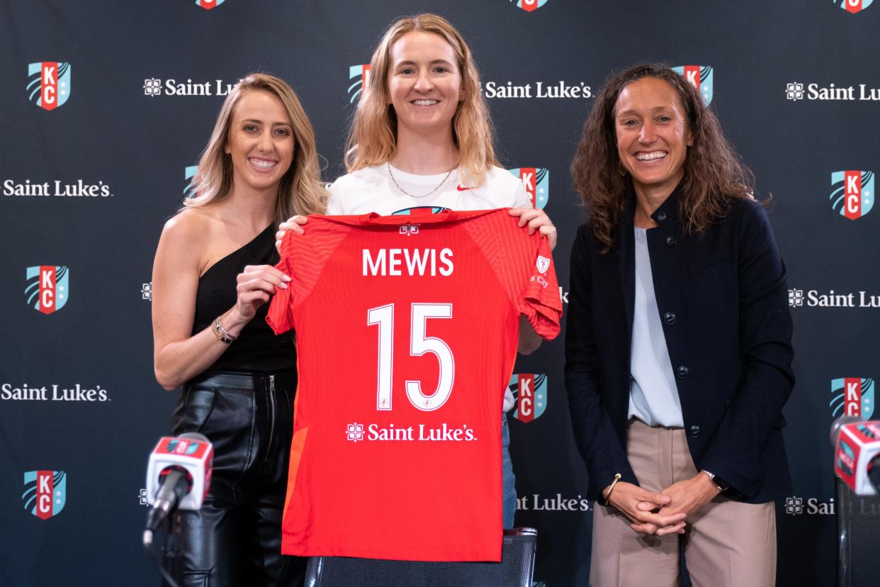 Flanked by Kansas City Current co-owners Brittany Matthews, left, and Angie Long, right, former Whitman-Hanson High soccer star Sam Mewis shows off her new jersey during a news conference on Friday, Dec. 3, 2021.