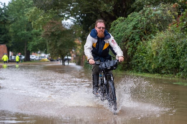 A man cycles through floodwater in Cossington, Leiceste