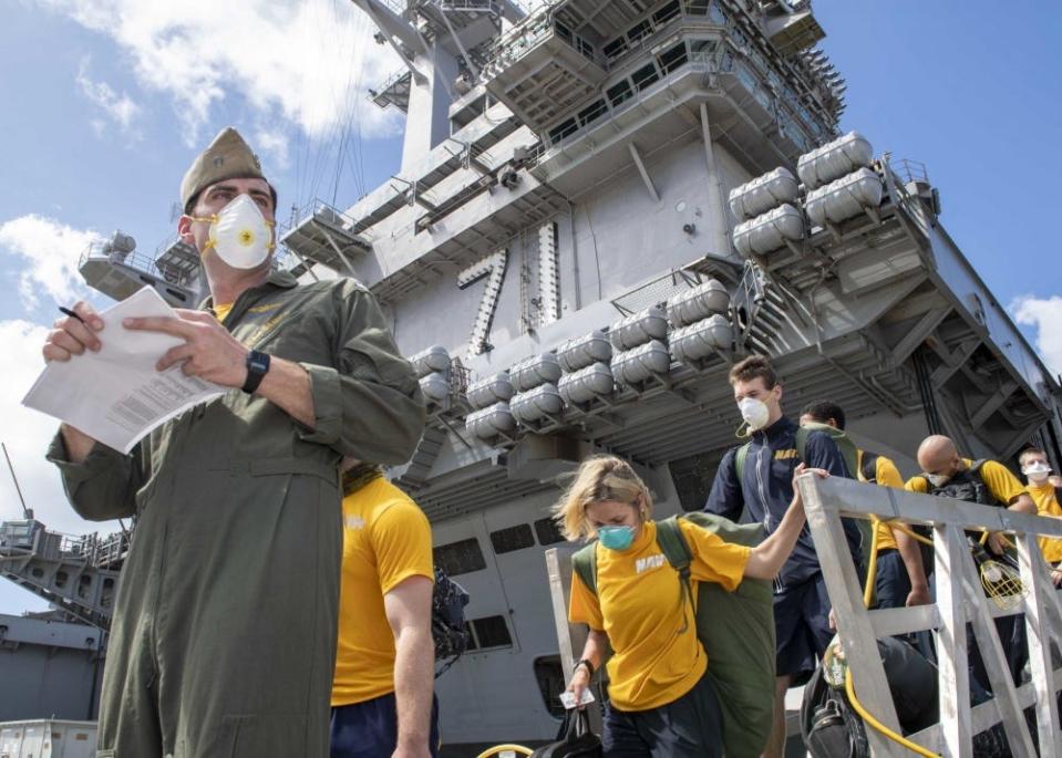 U.S. Sailors assigned to the aircraft carrier USS Theodore Roosevelt (CVN 71) depart the ship to move to off-ship berthing April 10, 2020