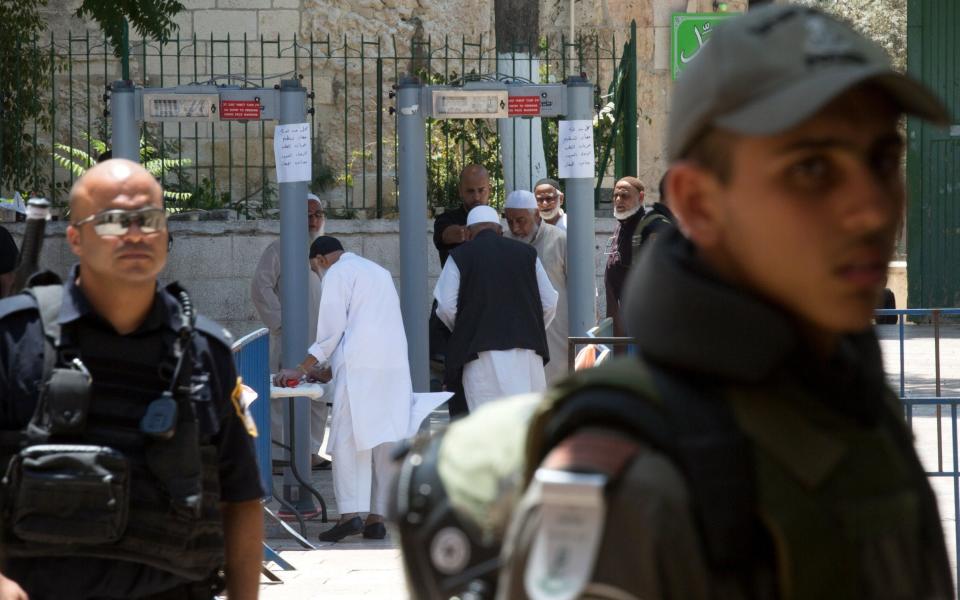  Palestinian worshipers pass through the new metal detectors at the entrance to the Al-Aqsa compound - Credit: EPA/ATEF SAFADI