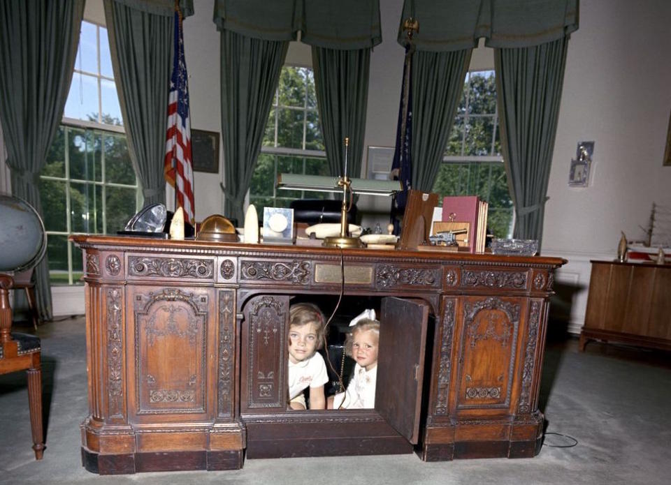 President John F. Kennedy's daughter Caroline and her cousin Kerry under the Resolute desk.