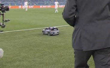 Suited man takes ball towards remote controlled car - BBC