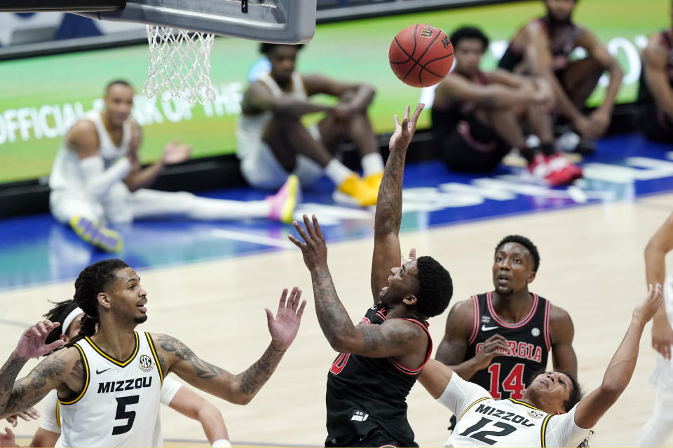 Georgia's K.D. Johnson (0) reaches for the ball between Missouri's Mitchell Smith (5) and Dru Smith (12) in the first half of an NCAA college basketball game in the Southeastern Conference Tournament Thursday, March 11, 2021, in Nashville, Tenn. (AP Photo/Mark Humphrey)
