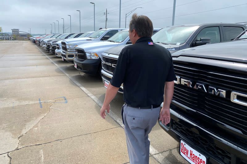 Jerry Bill, general manager of Stew Hansen Chrysler Dodge Jeep Ram, walks past a line of Ram trucks in Urbandale