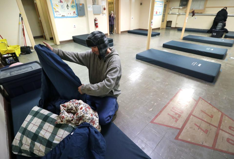 Zach Taylor prepares his mat to spend the night Dec. 8, 2021, at Day By Day Warming Shelter, 449 High Ave. Guests arrive when the shelter opens at 6 p.m., and it can hold up to 25 guests. The temporary shelter is open overnight October through April and this season has already turned away people 153 times, up from 72 total last season.