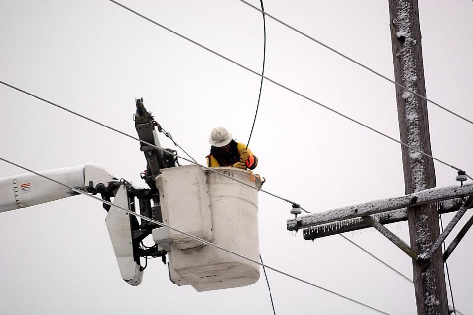 Inside a bucket above the the street, a lineman for Ohio Edison gets ready to reconnect a wire that came down in 2018 in front of Hoover Price Campus Center at Mount Union in Alliance.