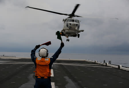 Akiko Ihara, a female flight deck crew of Japanese helicopter carrier Kaga, guides for the landing of a SH-60K Sea Hawk helicopter on the flight deck in the Indian Ocean, Indonesia, September 24, 2018. "Women all over the world are working in a wider number of areas and I think Japan needs to be a part of that," said Ihara. "We all work in different teams around the ship but we are all friends," Ihara added. "We do sometimes moan a little about our male colleagues." REUTERS/Kim Kyung-Hoon