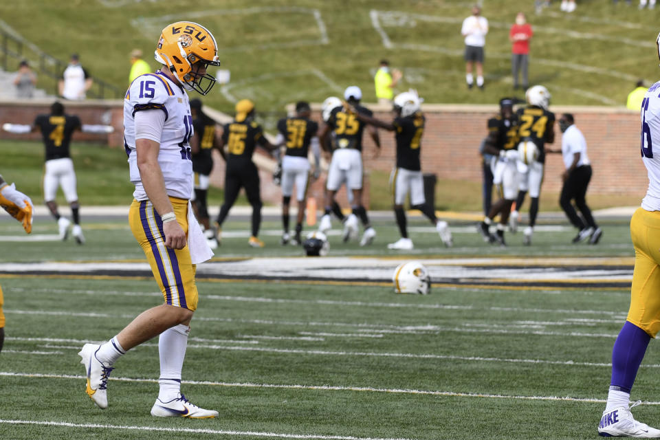 LSU quarterback Myles Brennan heads off the field as members of the Missouri Tigers celebrate an LSU turnover on downs in the final seconds of an NCAA college football game Saturday, Oct. 10, 2020, in Columbia, Mo. Missouri upset LSU 45-41. (AP Photo/L.G. Patterson)