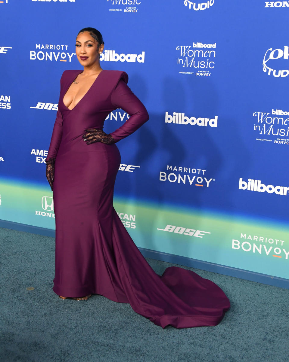 She's in a long-sleeve gown with a plunging neckline and train