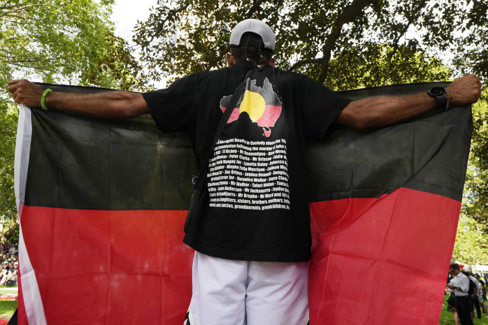 A man holds an Aboriginal flag at an Indigenous Australians protest during Australia Day in Sydney, Friday, Jan. 26, 2024. Thousands of Australians protest on the anniversary of British colonization of their country amid fierce debate over whether the increasingly polarizing national holiday dubbed 'Australia Day' should be moved to another date. (AP Photo/Rick Rycroft)