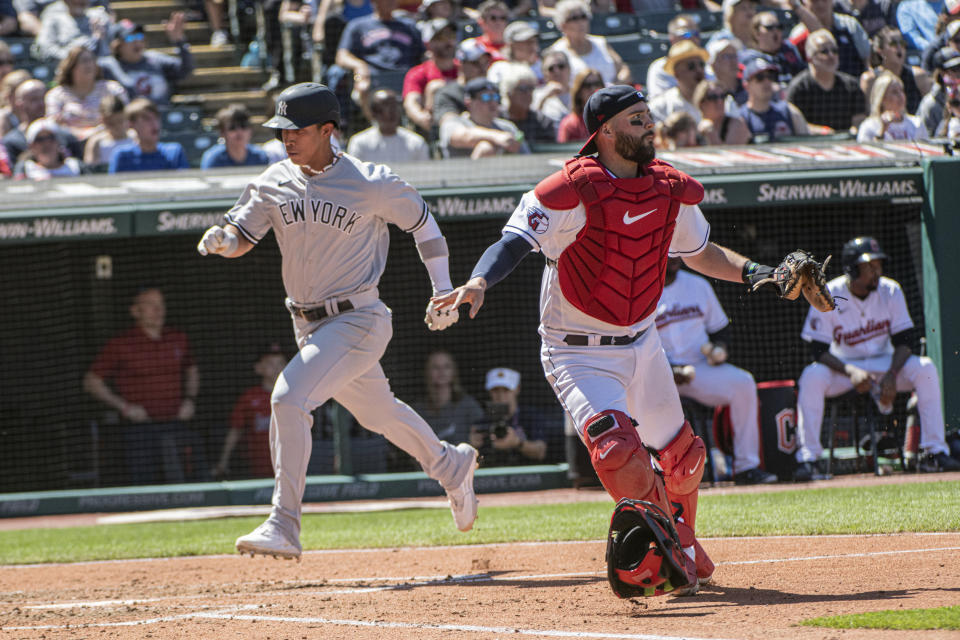 New York Yankees' Oswaldo Cabrera scores on an RBI single by Kyle Higashioka as Cleveland Guardians' Cam Gallagher waits for the throw in the fifth inning of a baseball game in Cleveland, Wednesday April 12, 2023. (AP Photo/Phil Long)