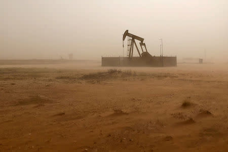 FILE PHOTO: A pump jack lifts oil out of a well, during a sandstorm in Midland, Texas, U.S., April 13, 2018. REUTERS/Ann Saphir/File Photo