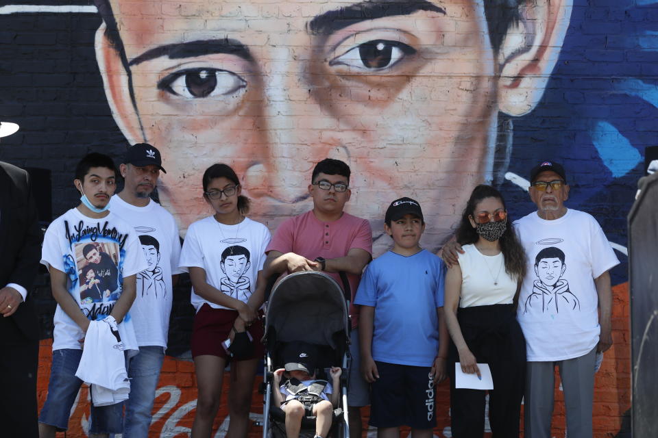 Family members of police shooting victim 13-year-old Adam Toledo stand in front of a mural painted in his honor during a news conference announcing the opening of Adam's Place Inc., a not-for profit organization aiming to help at-risk youth from Chicago and other Midwestern cities to remain out of trouble, Wednesday, May 26, 2021 in Chicago's West Side. (AP Photo/Shafkat Anowar)