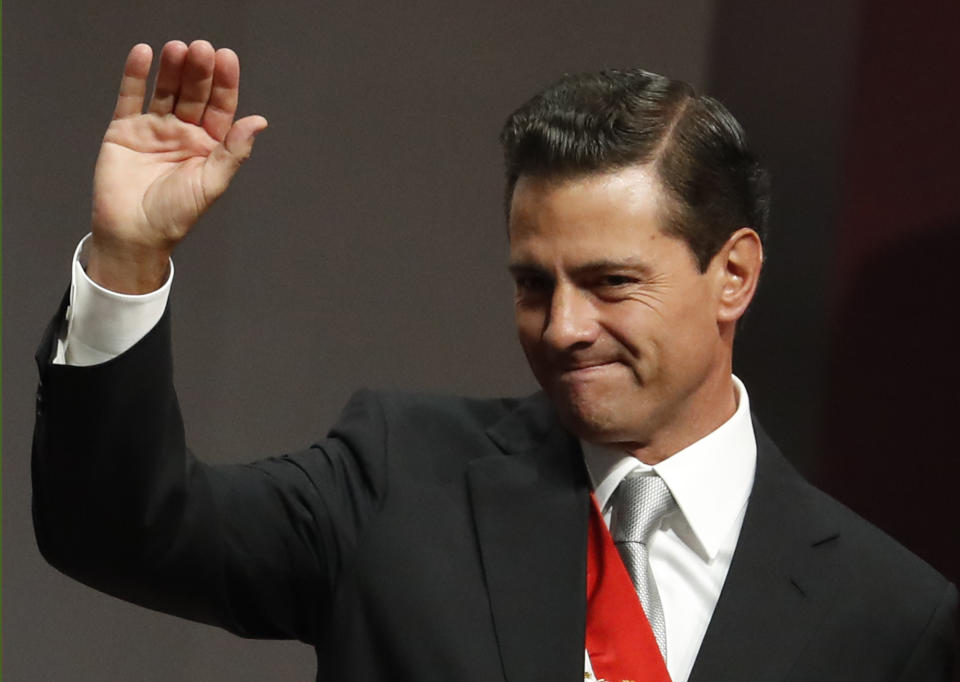 Mexican President Enrique Pena Nieto waves to supporters after delivering his sixth and final State of the Nation address at the National Palace in Mexico City, Monday, Sept. 3, 2018. President-elect and longtime opposition leader Andres Manuel Lopez Obrador will take over the reigns of power on December 1. (AP Photo/Rebecca Blackwell)