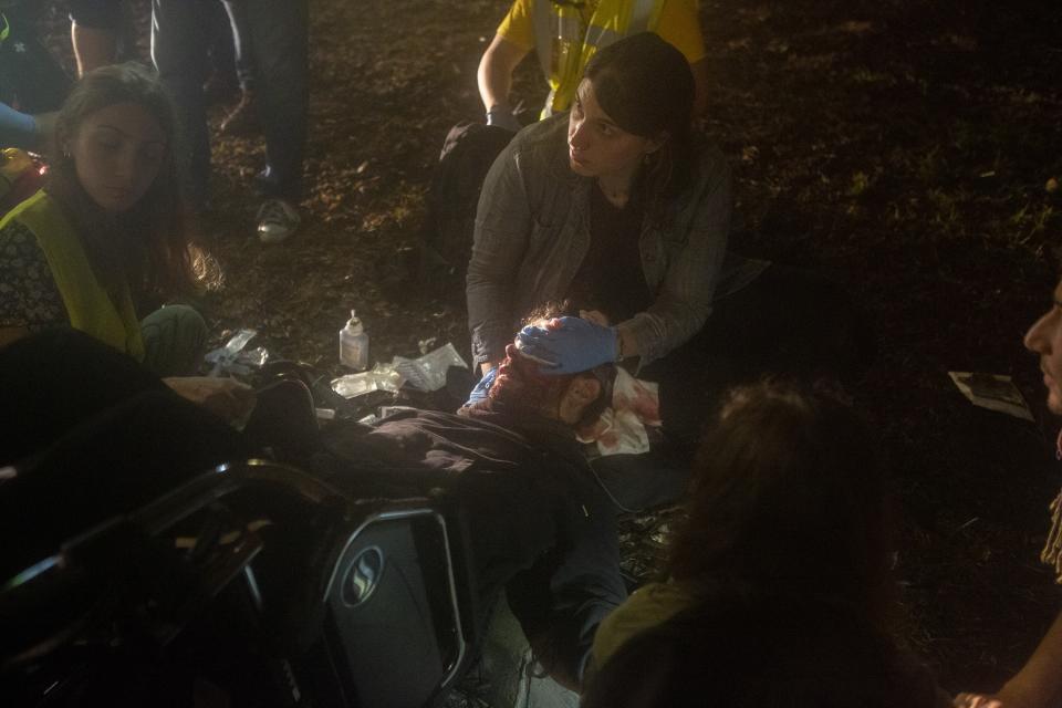 In this Monday, Oct. 14, 2019 photo, an injured pro-independence protesters lays on the ground during a demonstration at El Prat airport, outskirts of Barcelona, Spain. Riot police engaged in a running battle with angry protesters outside Barcelona's airport Monday after Spain's Supreme Court convicted 12 separatist leaders of illegally promoting the wealthy Catalonia region's independence and sentenced nine of them to prison. (AP Photo/Joan Mateu)