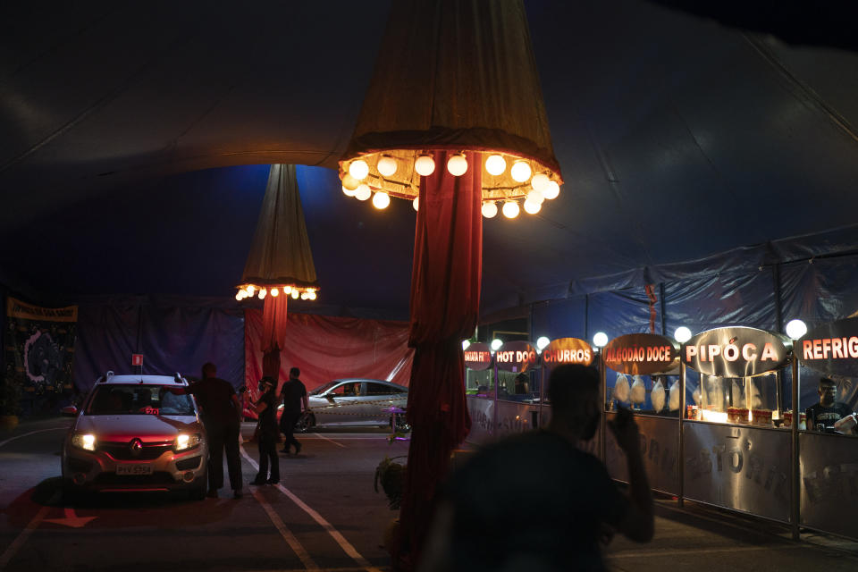 Cars arrive at the Estoril Circus during the coronavirus pandemic in Itaguai greater Rio de Janeiro, Brazil, Saturday, July 18, 2020. Following the measures to curb the spread of the COVID-19, artists of this circus have decided to go back to work in a different way, as a circus drive-in. (AP Photo/Leo Correa)