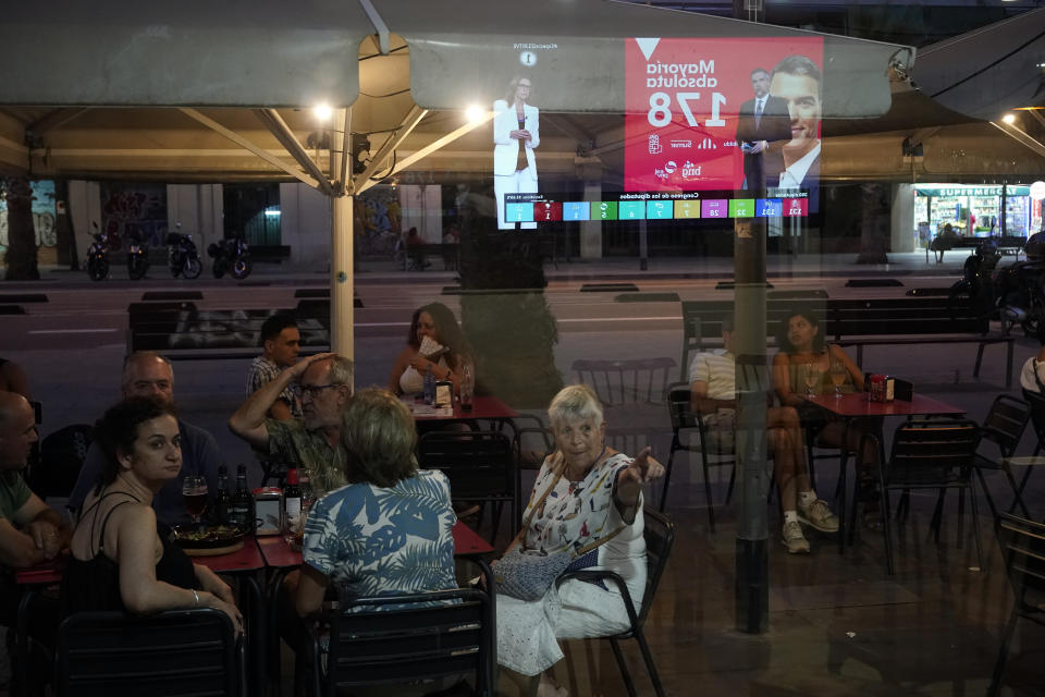 People watches news about the election results at a terrace in a bar in Barcelona, Spain, Sunday July 23, 2023. Spain is holding general elections, that could make the country the latest European Union member to swing to the political right, at the height of summer, when millions of citizens are likely to be vacationing away from their regular polling places.(AP Photo/Joan Mateu Parra)