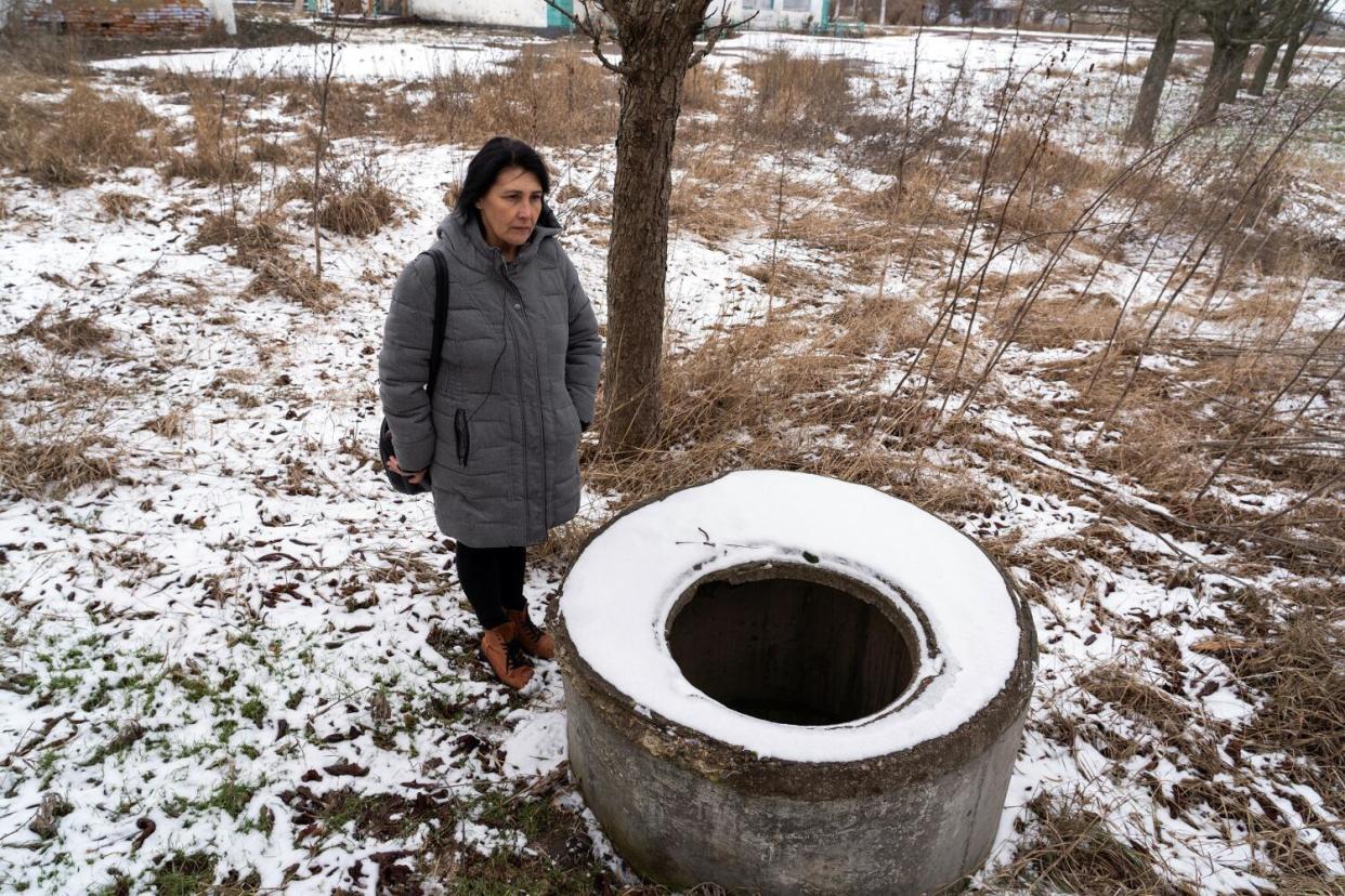 Olena Kovalyk pauses by a drainage well in Bilyayivka