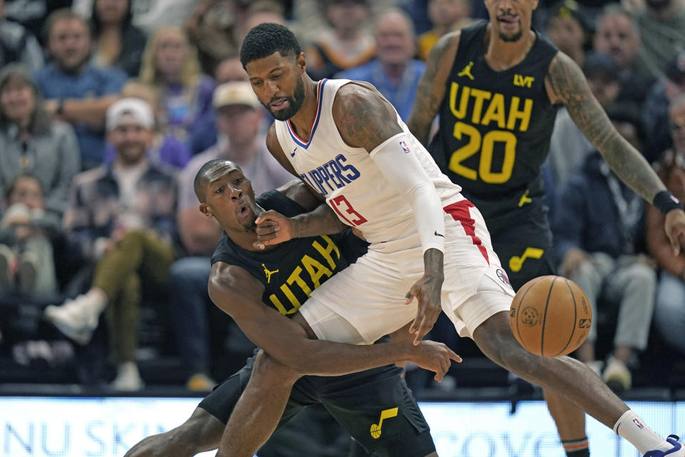 Utah Jazz guard Kris Dunn, left, knocks the ball from Los Angeles Clippers forward Paul George (13) during the first half of an NBA basketball game Friday, Oct. 27, 2023, in Salt Lake City. (AP Photo/Rick Bowmer)