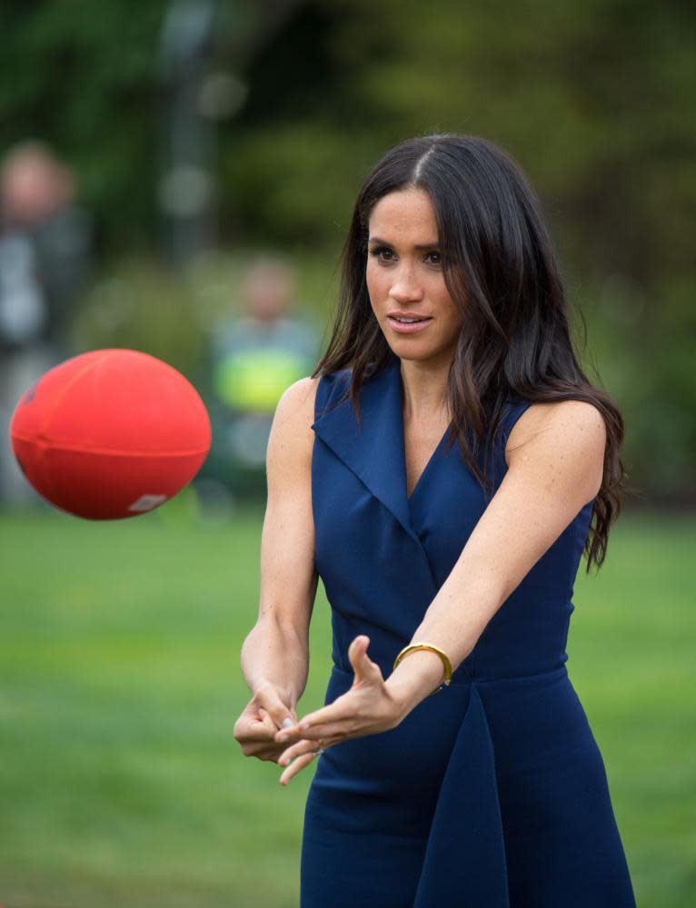 Meghan, Duchess of Sussex, handballs an Australian Rules football