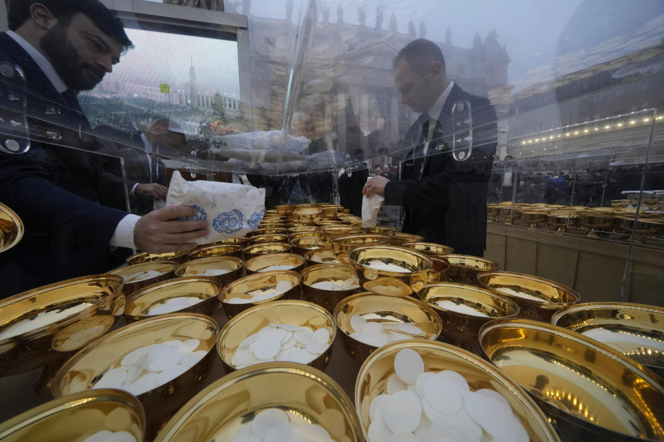 Holy communion vessels are filled ahead of the funeral mass for late Pope Emeritus Benedict XVI in St. Peter's Square at the Vatican, Thursday, Jan. 5, 2023. Benedict died at 95 on Dec. 31 in the monastery on the Vatican grounds where he had spent nearly all of his decade in retirement. (AP Photo/Andrew Medichini)
