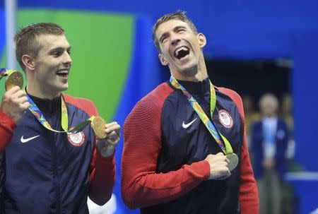2016 Rio Olympics - Swimming - Victory Ceremony - Men's 4 x 100m Freestyle Relay Victory Ceremony - Olympic Aquatics Stadium - Rio de Janeiro, Brazil - 07/08/2016. Michael Phelps (USA) of USA laughs beside Ryan Held (USA) of USA as they pose with their gold medals. REUTERS/Dominic Ebenbichler
