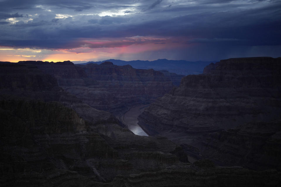 The sun sets over the Colorado River at Guano Point on the Hualapai reservation Monday, Aug. 15, 2022, in northwestern Arizona. Roughly 600,000 tourists a year visit the Grand Canyon on the Hualapai reservation in northwestern Arizona — an operation that's the tribe's main source of revenue. (AP Photo/John Locher)