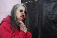 An abortion opponent offers silent prayer while wearing a tape across her mouth with the word "Life" written across it, while standing outside the Jackson Women's Health Organization, a state-licensed abortion clinic in Jackson, Miss., Wednesday, Dec. 1, 2021. A group of anti-abortion activists stood outside the clinic in an effort to dissuade patients from entering. On Wednesday, the U.S. Supreme Court heard a case that directly challenges the constitutional right to an abortion established nearly 50 years ago. (AP Photo/Rogelio V. Solis)