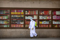 A worker sprays disinfectant outside the Beijing Railway Station in Beijing, Saturday, Feb. 15, 2020. People returning to Beijing will now have to isolate themselves either at home or in a concentrated area for medical observation, said a notice from the Chinese capital's prevention and control work group published by state media late Friday. (AP Photo/Mark Schiefelbein)