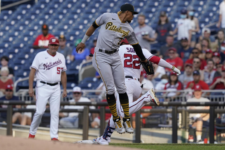 Washington Nationals Juan Soto (22) is safe at first as Pittsburgh Pirates second baseman Erik Gonzalez (2) reaches for the tag during the first inning of a baseball game, Monday, June 14, 2021, in Washington. The call on the field was out but was overturned after a review. (AP Photo/Carolyn Kaster)