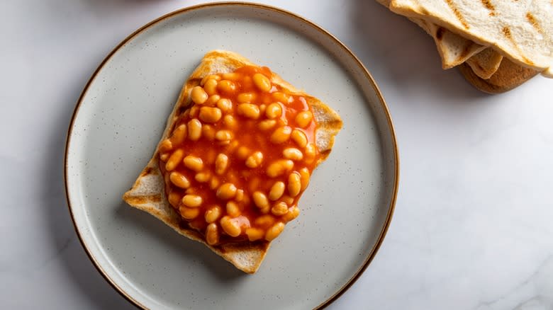 white plate with beans and tomato sauce on toast