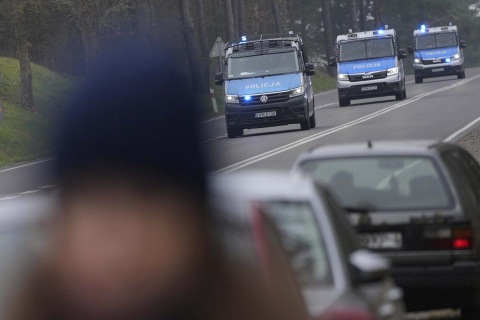 Polish police cars drive past a check point close to the border with Belarus near Kuznica, Poland, Tuesday, Nov. 16, 2021. (AP Photo/Matthias Schrader)