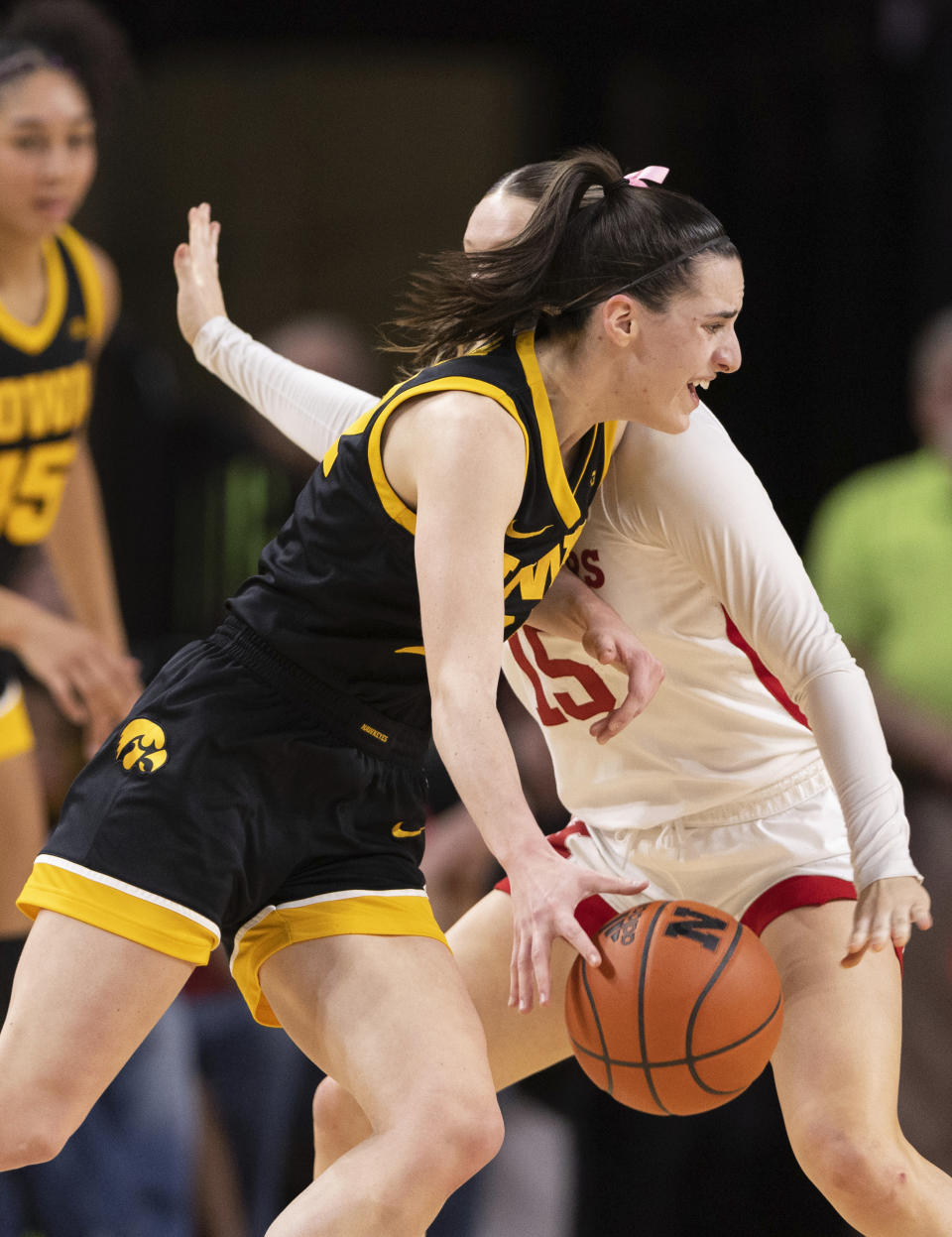 Iowa's Caitlin Clark, front, drives against Nebraska's Kendall Moriarty, back, during the first half of an NCAA college basketball game Sunday, Feb. 11, 2024, in Lincoln, Neb. (AP Photo/Rebecca S. Gratz)