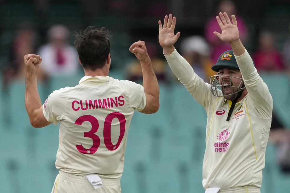 Australia's Pat Cummins, left,, celebrates with teammate Travis Head after taking the wicket of South Africa's Khaya Zondo during the fourth day of their cricket test match at the Sydney Cricket Ground in Sydney, Saturday, Jan. 7, 2023. (AP Photo/Rick Rycroft)