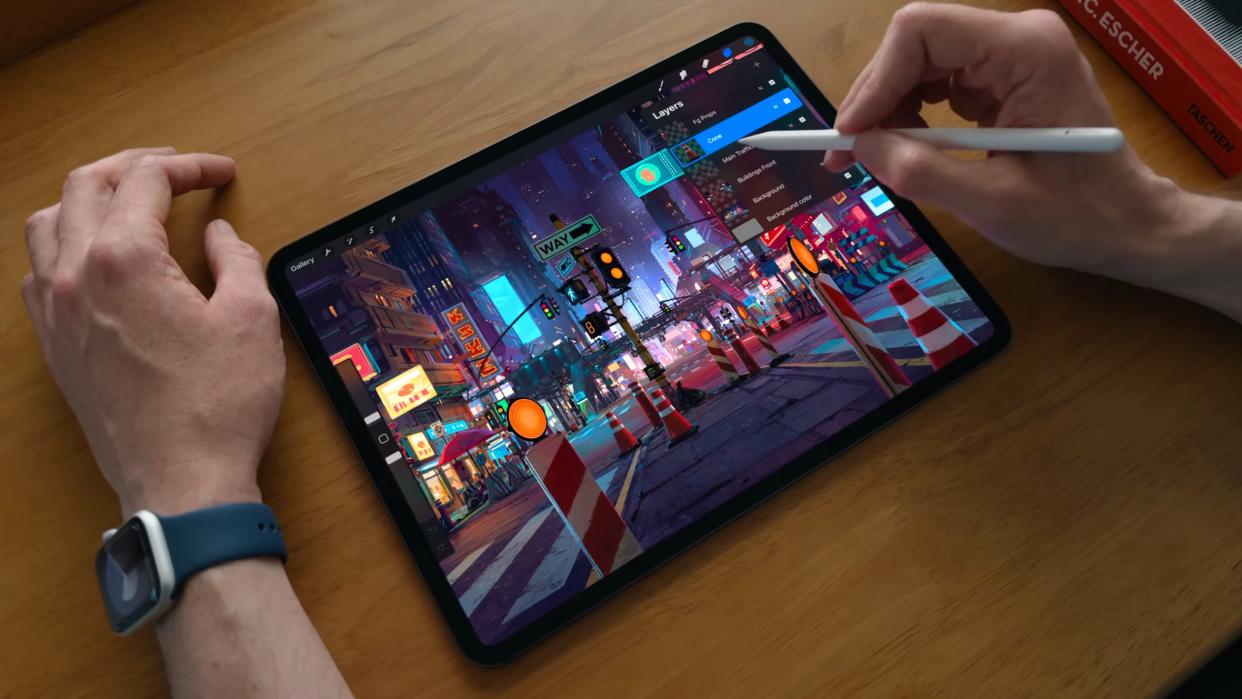  Someone using the Apple Pencil to illustrate a night street scene on an iPad Pro OLED. 