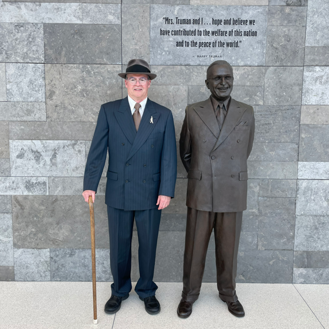 John Pritchard poses beside a statue of the president he sometimes impersonates.