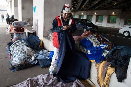 Blanca Rodriguez, 46, organizes her bedding under an overpass in Chicago, December 4, 2014. Rodriguez has been living under the overpass for 3 months. REUTERS/Andrew Nelles